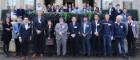 Group photo of attendees of the JEOL International CryoARM meeting on steps outside a stone building