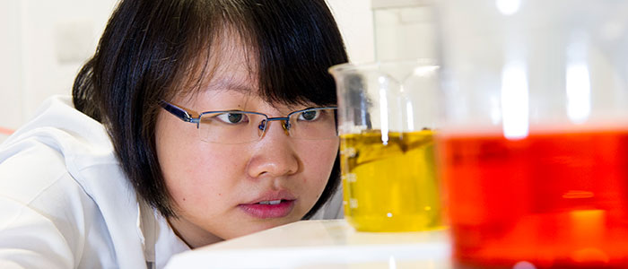 Girl with beakers of red and yellow dye