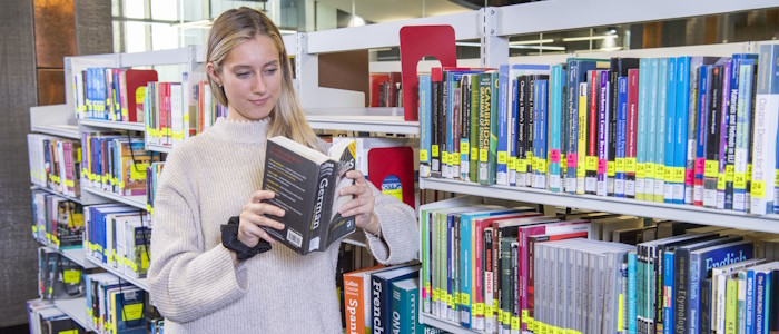 A language student looking through language books in the library